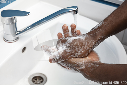 Image of Man washing hands carefully in bathroom close up. Prevention of infection and pneumonia virus spreading