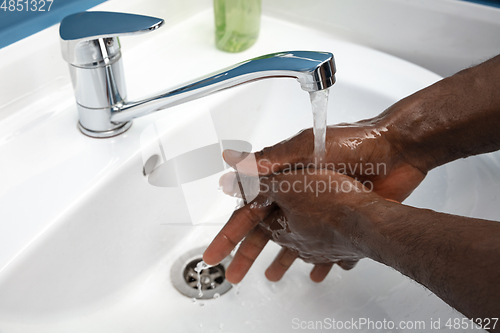 Image of Man washing hands carefully in bathroom close up. Prevention of infection and pneumonia virus spreading