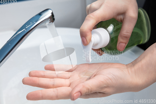 Image of Woman washing hands carefully in bathroom close up. Prevention of infection and pneumonia virus spreading