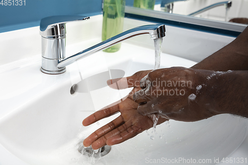 Image of Man washing hands carefully in bathroom close up. Prevention of infection and pneumonia virus spreading