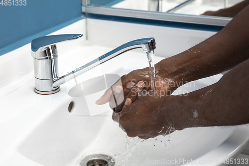 Image of Man washing hands carefully in bathroom close up. Prevention of infection and pneumonia virus spreading