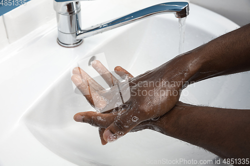 Image of Man washing hands carefully in bathroom close up. Prevention of infection and pneumonia virus spreading