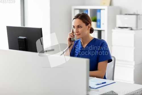 Image of doctor with computer calling on phone at hospital