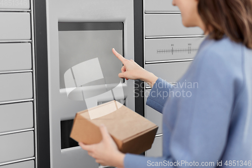 Image of smiling woman with box at automated parcel machine