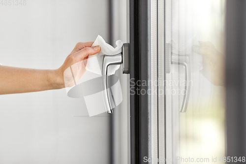 Image of woman cleaning window handle with wet wipe