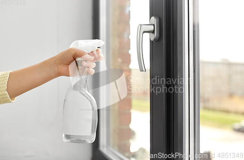 Image of hands cleaning window handle with detergent