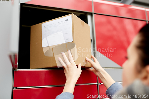 Image of woman putting box to automated parcel machine