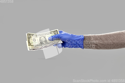 Image of close up of hand in medical glove with money