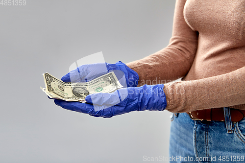 Image of close up of hand in medical glove with money