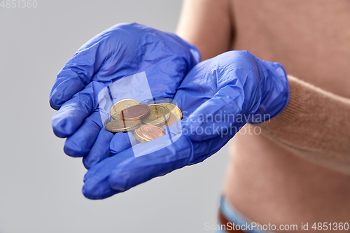 Image of close up of hands in medical gloves with money