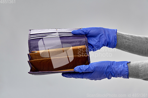 Image of close up of hands in gloves with empty wallet