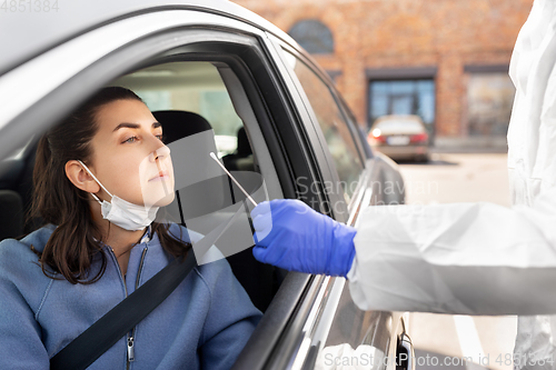 Image of healthcare worker making coronavirus test at car