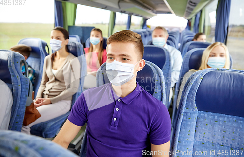 Image of young man in mask sitting in travel bus or train