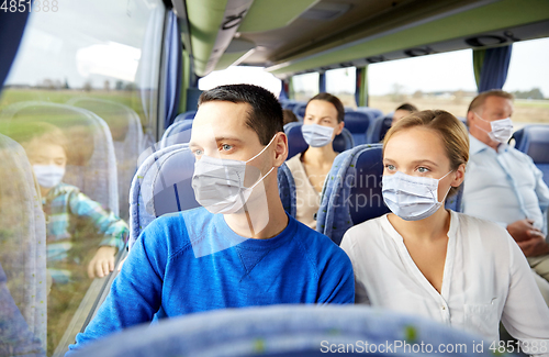 Image of couple or passengers in masks in travel bus