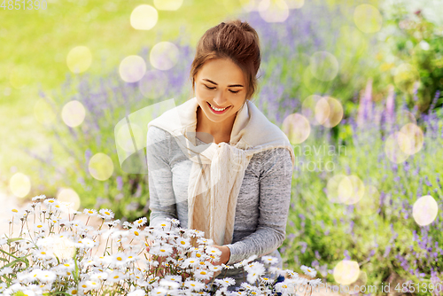 Image of young woman with flowers at summer garden