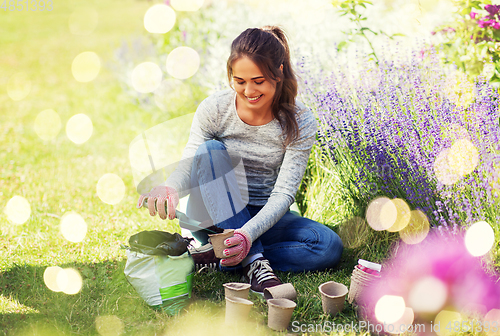 Image of woman filling pots with soil at summer garden