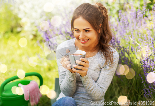 Image of young woman drinking tea at summer garden