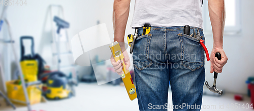 Image of man with level and working tools in pockets