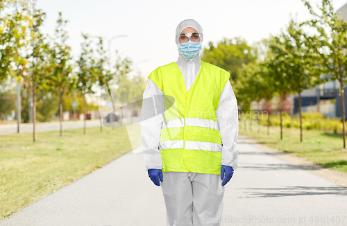 Image of sanitation worker in hazmat with pressure washer