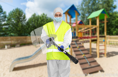 Image of sanitation worker in hazmat with pressure washer