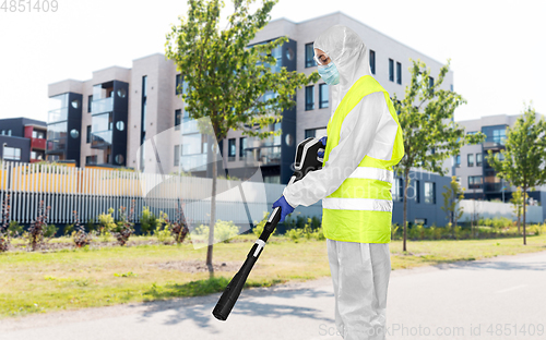 Image of sanitation worker in hazmat with pressure washer