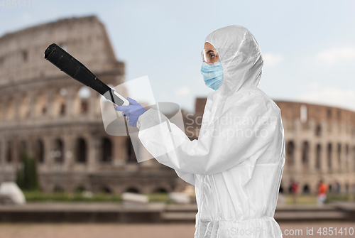 Image of sanitation worker in hazmat with pressure washer