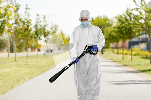 Image of sanitation worker in hazmat with pressure washer