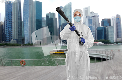 Image of sanitation worker in hazmat with pressure washer