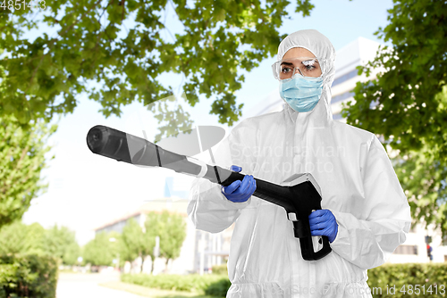 Image of sanitation worker in hazmat with pressure washer