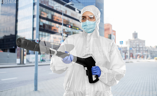 Image of sanitation worker in hazmat with pressure washer