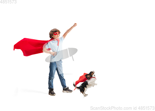 Image of Child pretending to be a superhero with his super dog isolated on white studio background