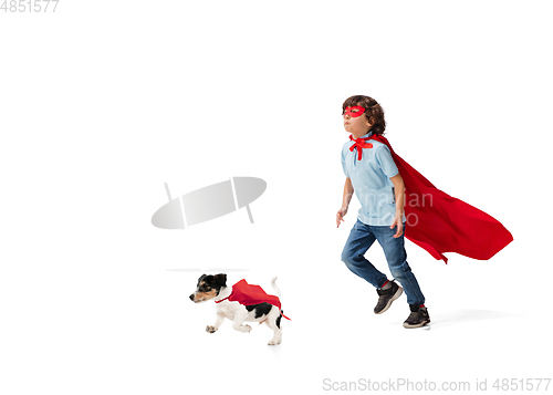Image of Child pretending to be a superhero with his super dog isolated on white studio background