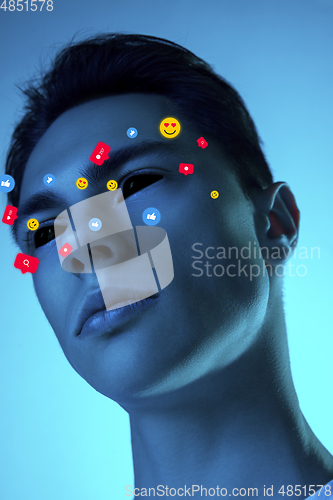 Image of Tears illustrated of social media activity signs on male face in neon light. Real life versus online lifestyle, addiction to modern technologies