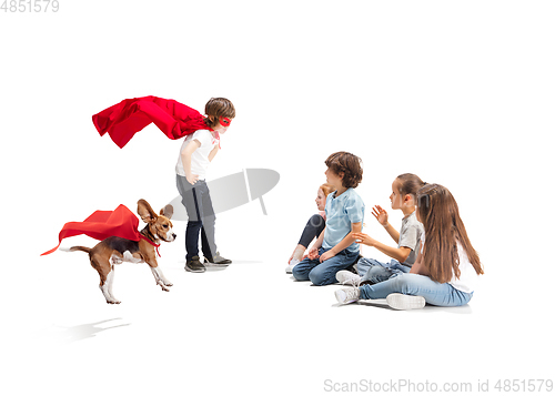 Image of Child pretending to be a superhero with his super dog and friends sitting around