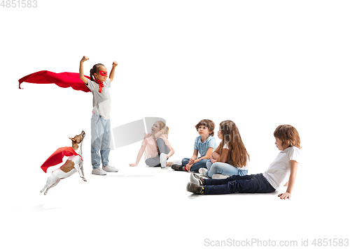 Image of Child pretending to be a superhero with her super dog and friends sitting around