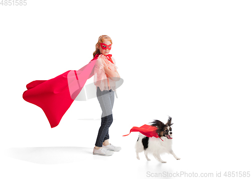 Image of Child pretending to be a superhero with her super dog isolated on white studio background