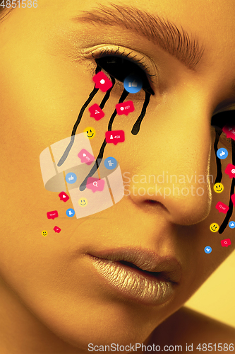 Image of Tears illustrated of social media activity signs on female face in neon light. Real life versus online lifestyle, addiction to modern technologies