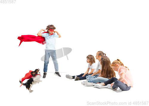 Image of Child pretending to be a superhero with his super dog and friends sitting around