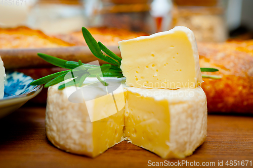 Image of French cheese and fresh  baguette on a wood cutter