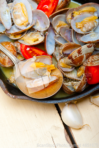 Image of fresh clams on an iron skillet