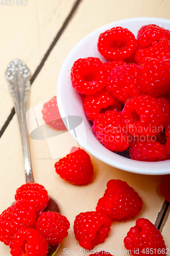Image of bunch of fresh raspberry on a bowl and white table