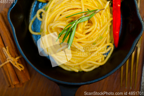 Image of italian spaghetti pasta with zucchini sauce on iron skillet