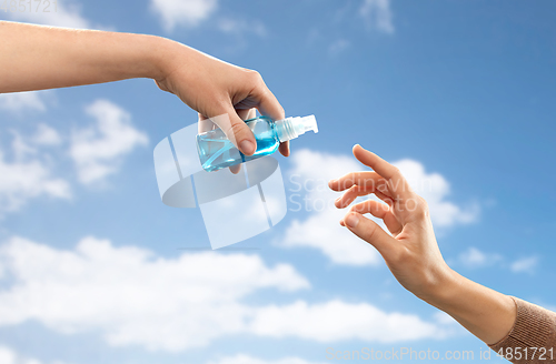 Image of close up of hands giving each other gel sanitizer