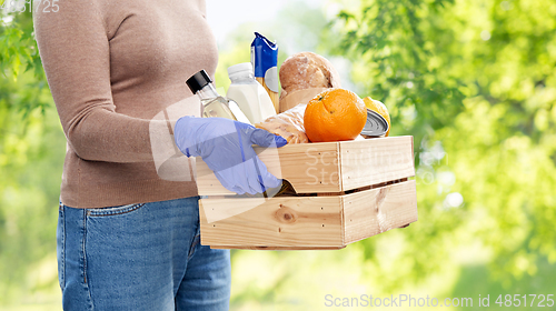 Image of woman in gloves with food in wooden box