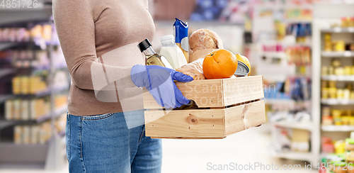 Image of woman in gloves with food in wooden box