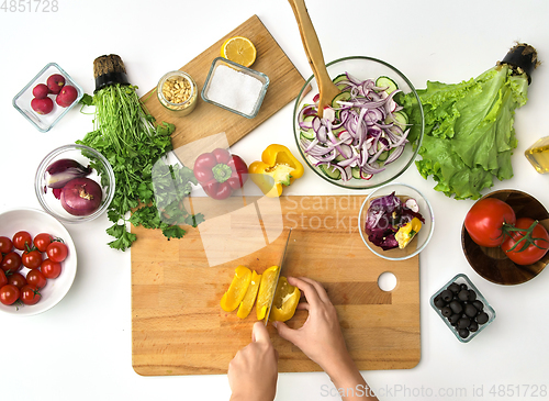 Image of hands chopping pepper for salad at kitchen