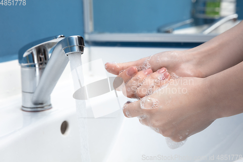 Image of Woman washing hands carefully in bathroom close up. Prevention of infection and pneumonia virus spreading