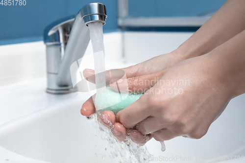 Image of Woman washing hands carefully in bathroom close up. Prevention of infection and pneumonia virus spreading