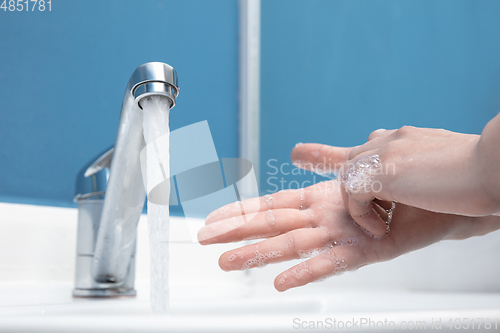 Image of Woman washing hands carefully in bathroom close up. Prevention of infection and pneumonia virus spreading