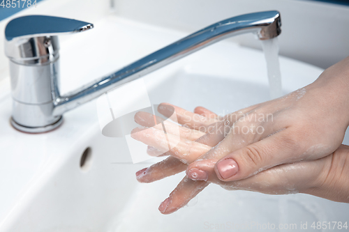 Image of Woman washing hands carefully in bathroom close up. Prevention of infection and pneumonia virus spreading